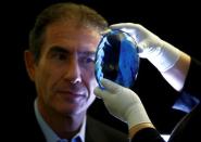 Philanthropist Maurice Ostro looks through his Ostro stone, the largest known blue topaz stone, for media at the Natural History Museum in London, Britain September 27, 2016. REUTERS/Peter Nicholls