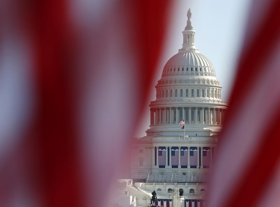 FILE - The U.S. Capitol is seen through a display of flags on the National Mall, one day after the inauguration of President Joe Biden, on Jan. 21, 2021, in Washington. Just over a year ago, millions of energized young people, women, voters of color and independents joined forces to send Joe Biden to the White House. But 12 months after he entered the Oval Office, many describe a coalition in crisis. (AP Photo/Rebecca Blackwell, File)