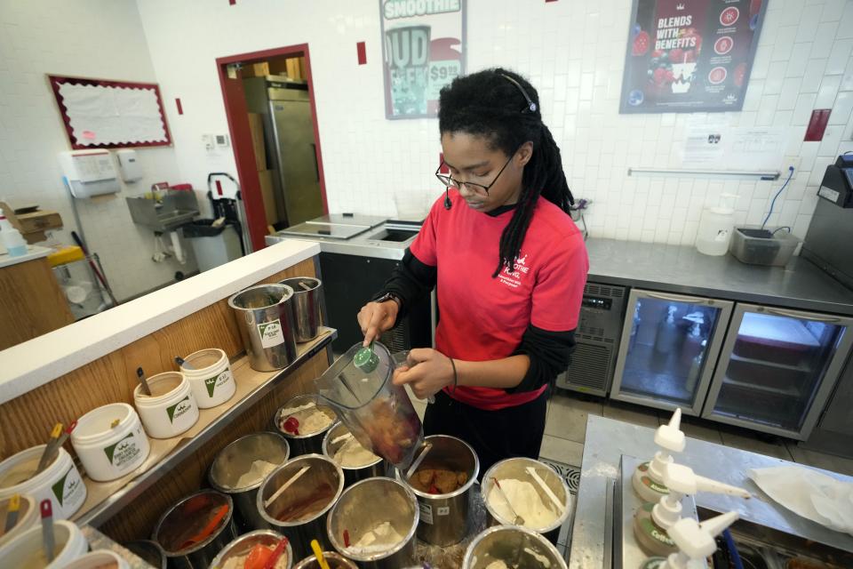 Asia Donald creates a smoothie at her employment, Tuesday, March 19, 2024, in Flint, Mich. Donald remembers feeling helpless and bewildered when her little sister developed rashes and her mom boiled pot after pot of bottled water for baths when the water crisis began 10 years ago. But just a couple years later, she was part of the Flint Public Health Youth Academy, which guided kids from Newark, N.J., as they went through their own lead-in-water crisis. (AP Photo/Carlos Osorio)