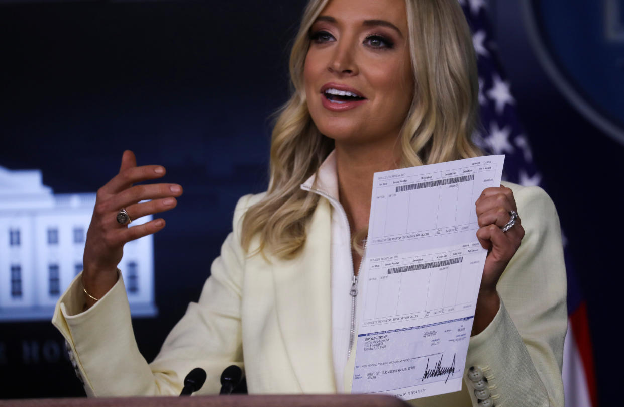 White House press secretary Kayleigh McEnany holds up a donation check signed by Donald Trump for $100,000 made out to the "Office of the Assistant Secretary for Health" &mdash; complete with bank account details. (Photo: Leah Millis/Reuters)