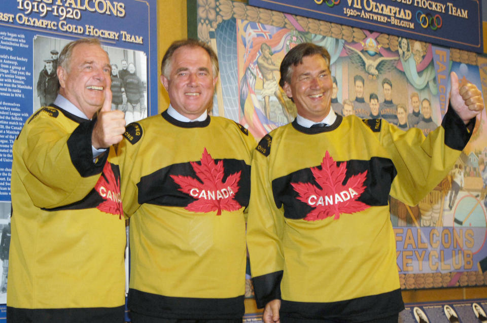 Canadian PM Martin, Icelandic PM Asgrimsson, and Manitoba Premier Doer try on Winnipeg Falcon jerseys in Winnipeg.  (L-R) Canada's Prime Minister Paul Martin, Iceland's Prime Minister Halldor Asgrimsson and Manitoba Premier Gary Doer try on Winnipeg Falcon jerseys while visiting an exhibit in Winnipeg July 29, 2005. The Winnipeg Falcons hockey team won the gold medal at the 1920 Olympic games and was made up of many second generation Icelanders. REUTERS/Fred Greenslade