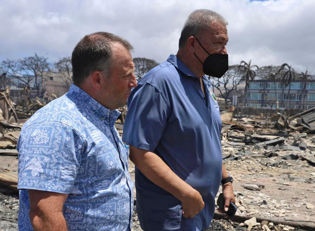 Hawaii Governor Josh Green, left, and Mayor Richard Bissen walk past the burned remains along Front Street in Lahaina (AP)