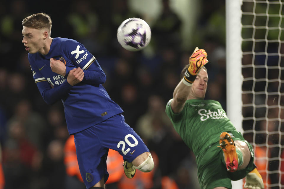 Chelsea's Cole Palmer, left, challenges for the ball with Everton's goalkeeper Jordan Pickford during the English Premier League soccer match between Chelsea and Everton at Stamford Bridge stadium in London, Monday, April 15, 2024. (AP Photo/Ian Walton)