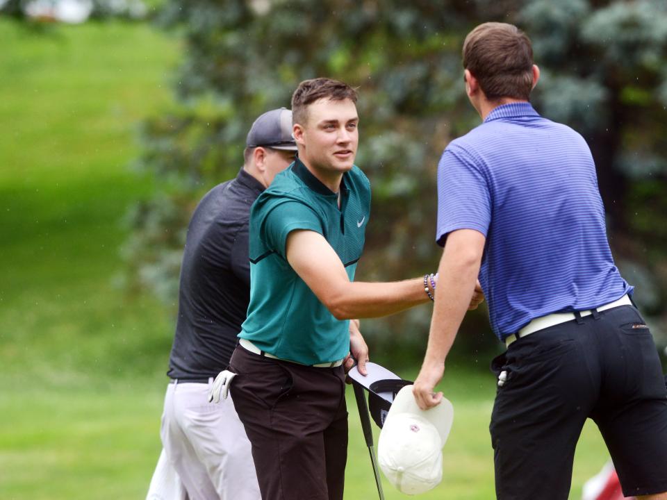 Cambridge native Ian Smith, left, shakes hands with Norwich's Blake Hartford after their final hole on Sunday during the second round of the Zanesville District Golf Association Amateur tournament at Jaycees. They shot matching 67s, with Hartford taking a two-shot lead into Saturday's final round at Zanesville Country Club.