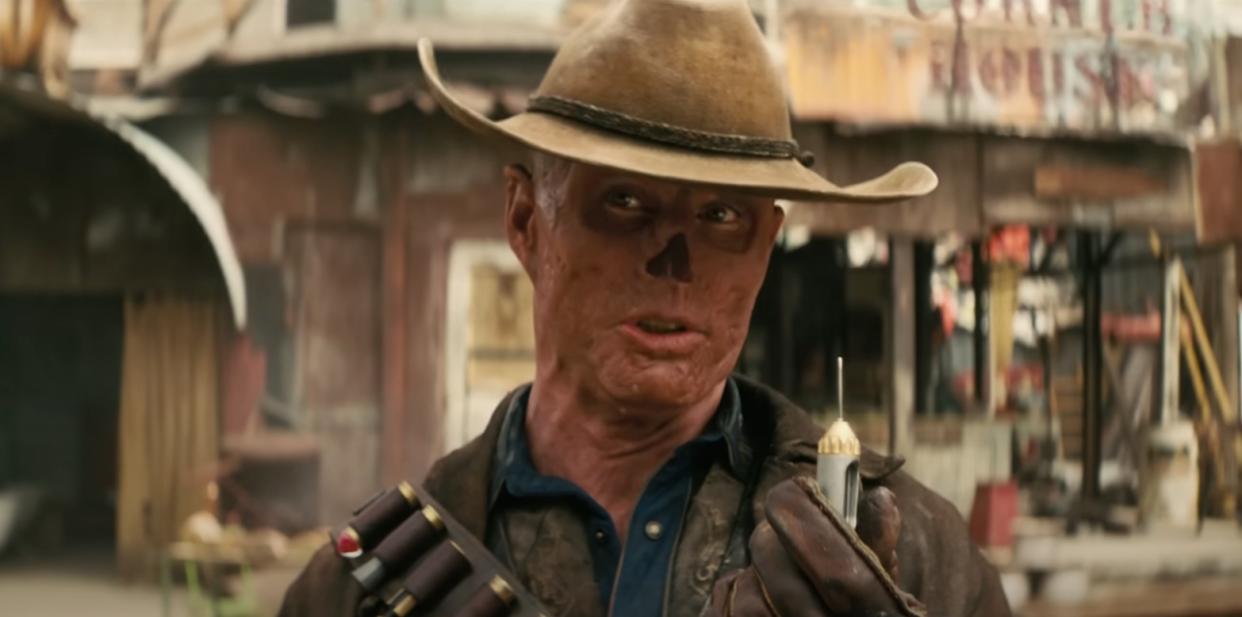  A post-apocalyptic cowboy with no nose displays a tranquilizer dart. 