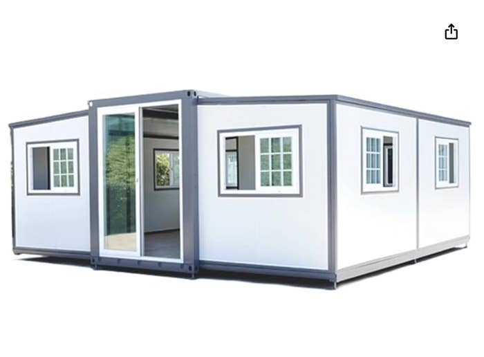 Modular container home with open glass door and several windows, isolated on a white background