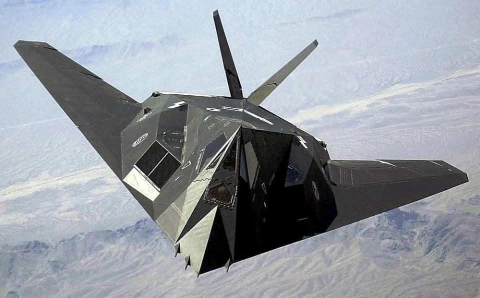 An F-117 Nighthawk flies over the Nevada desert. The unique design of the single-seat F-117 provides exceptional combat capabilities. The fighter can employ a variety of weapons and is equipped with sophisticated navigation and attack systems integrated into a digital avionics suite that increases mission effectiveness and reduces pilot workload. (Staff Sgt. Aaron D. Allmon II/Air Force)