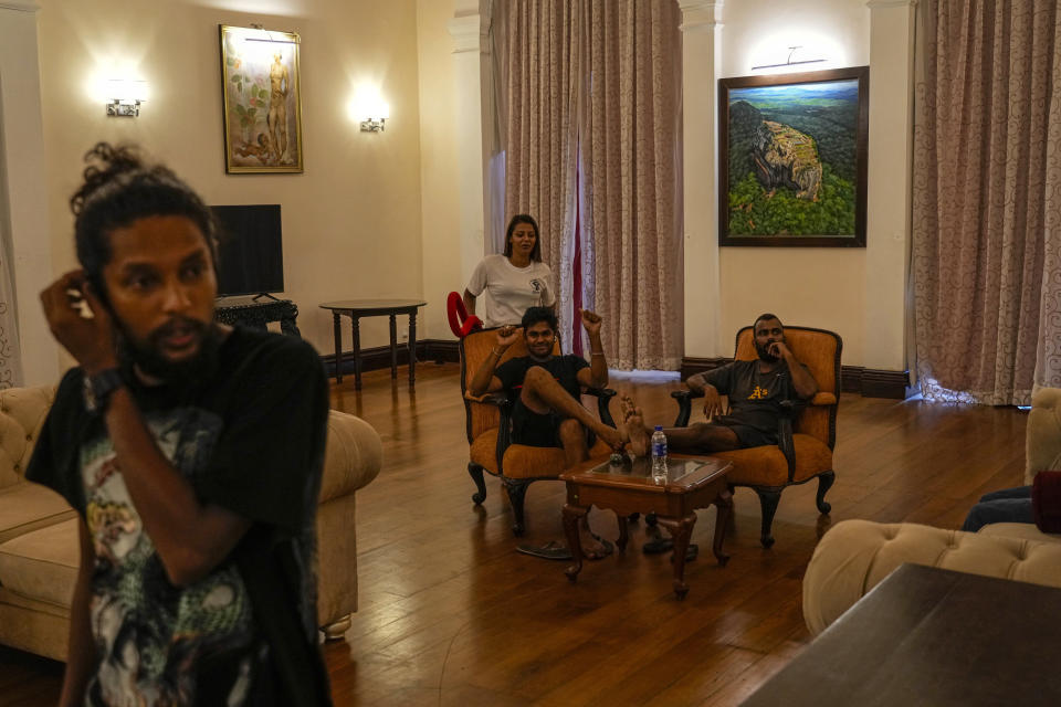Protesters sit on sofa inside the official residence of president Gotabaya Rajapaksa fourth days after it was stormed by anti government protesters in Colombo in Colombo, Sri Lanka, Wednesday, July 13, 2022. The president of Sri Lanka fled the country early Wednesday, days after protesters stormed his home and office and the official residence of his prime minister amid a monthslong economic crisis that triggered severe shortages of food and fuel.(AP Photo/Rafiq Maqbool)