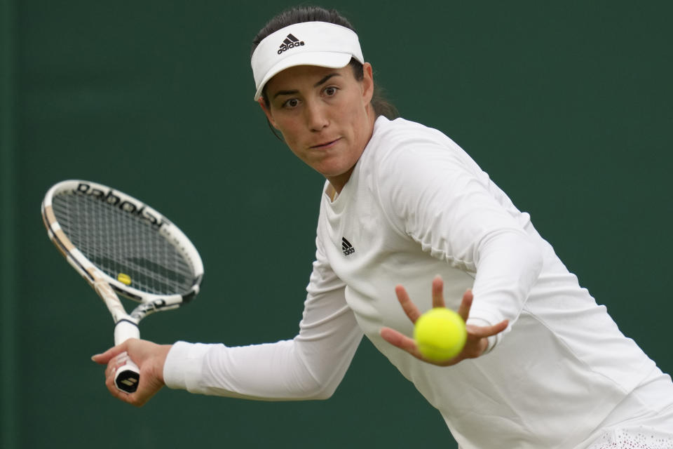 Spain's Garbine Muguruza returns the ball to Belgium's Greet Minnen during their singles tennis match on day two of the Wimbledon tennis championships in London, Tuesday, June 28, 2022. (AP Photo/Kirsty Wigglesworth)