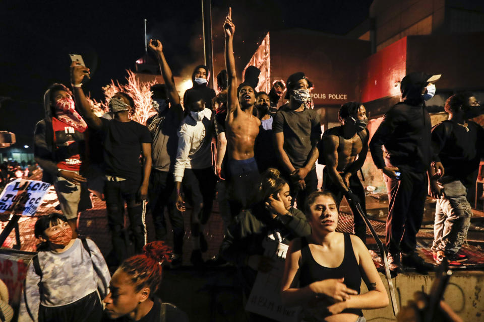 Protesters demonstrate outside of the burning precinct on May 28. | John Minchillo—AP