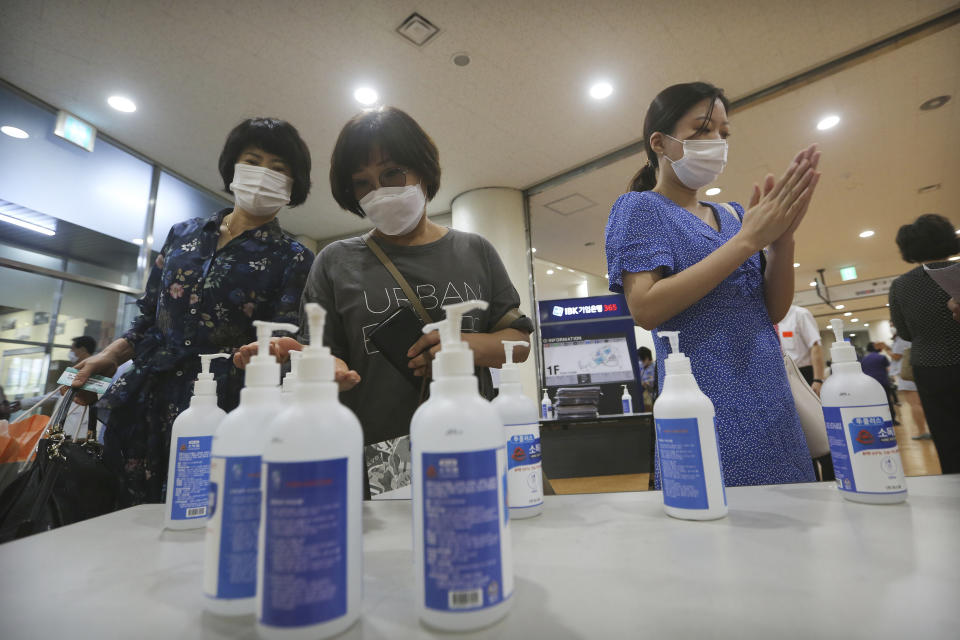 Christians wearing face masks to help protect against the spread of the new coronavirus use hand sanitizer before attending a service at the Yoido Full Gospel Church in Seoul, South Korea, Sunday, July 5, 2020. (AP Photo/Ahn Young-joon)
