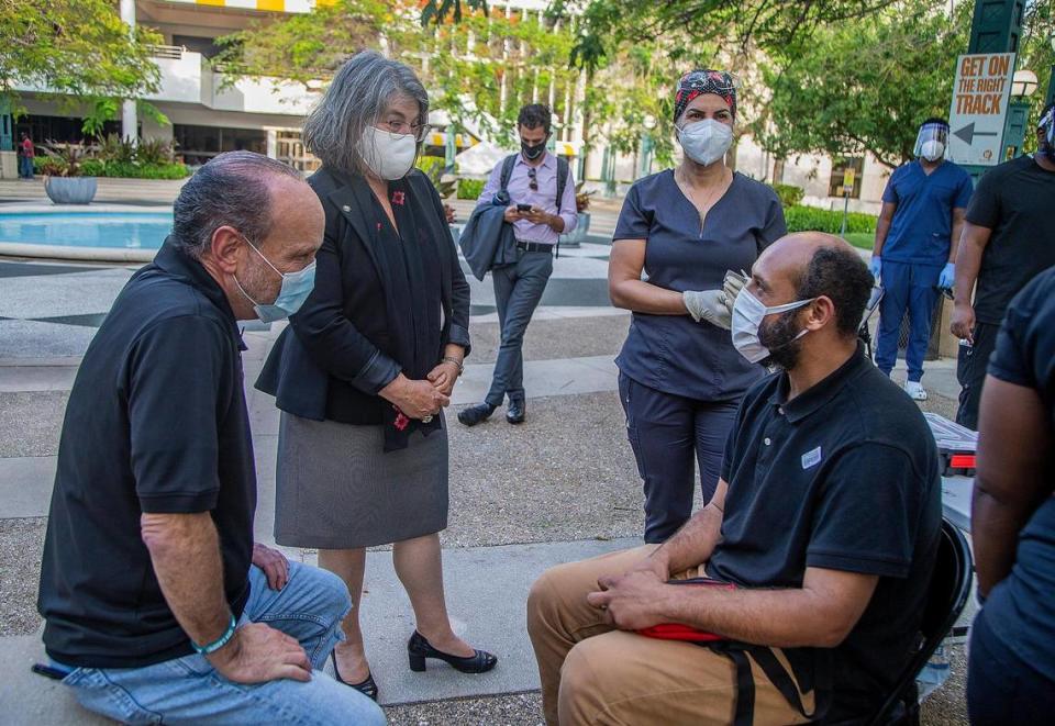 De izq. a der.: Ron L. Book, presidente del Homeless y la alcaldesa Daniella Levine Cava hablan con Uberne Vargas,un desamparado que vive en el downtown de Miami, tras ser vacunado contra el COVID-19.