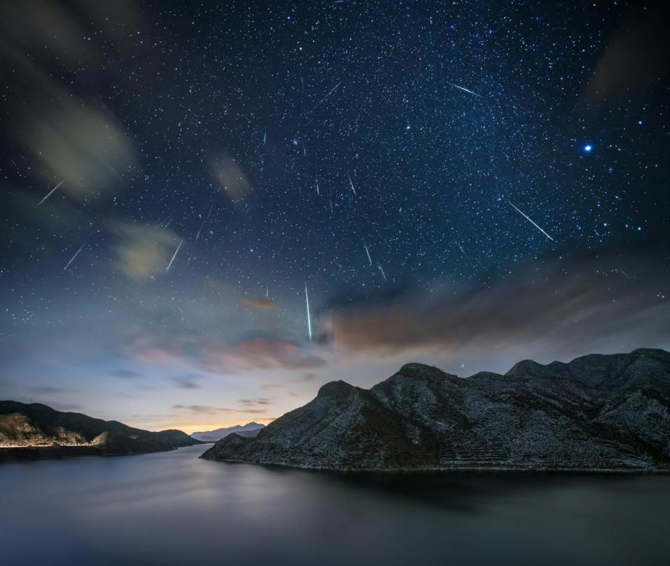 A photo showing a dark sky with various bright streaks that stand out for a meteor.