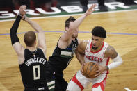 Houston Rockets' Kenyon Martin Jr., right, drives to the basket against Milwaukee Bucks' Pat Connaughton, middle, and Donte DiVincenzo, left, during the first half of an NBA basketball game Friday, May 7, 2021, in Milwaukee. (AP Photo/Aaron Gash)