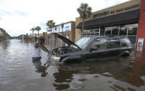 <p>John Duke tries to figure out how to salvage his flooded vehicle in the wake Hurricane Irma, Sept. 11, 2017, in Jacksonville, Fla. (Photo: John Bazemore/AP) </p>