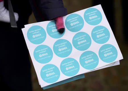 A protestor holds campaign stikers as she demonstrates during a doctors strike outside The Museum of The History of Science in Oxford, Britain February 10, 2016. REUTERS/Dylan Martinez