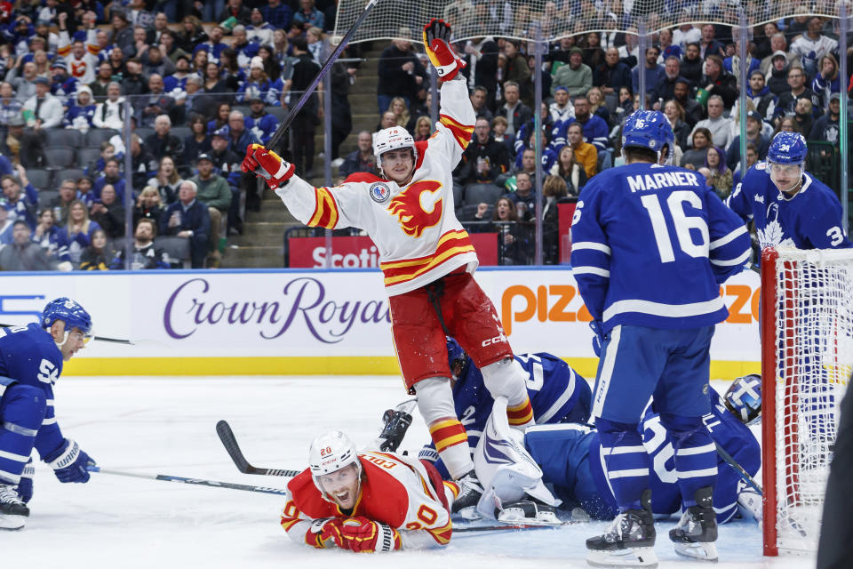 Calgary Flames' Martin Pospisil and Blake Coleman (20) celebrate Pospisil's game-tying goal against the Toronto Maple Leafs during the third period of an NHL hockey game Friday, Nov. 10, 2023, in Toronto. (Cole Burston/The Canadian Press via AP)