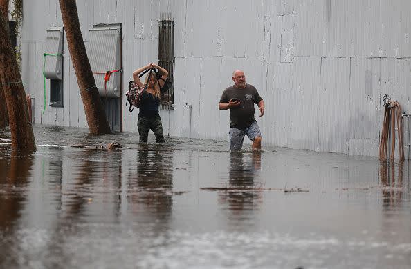 TARPON SPRINGS, FLORIDA - AUGUST 30: People wade through flood waters from Hurricane Idalia after it passed offshore on August 30, 2023 in Tarpon Springs, Florida. Hurricane Idalia is hitting the Big Bend area of Florida. (Photo by Joe Raedle/Getty Images)