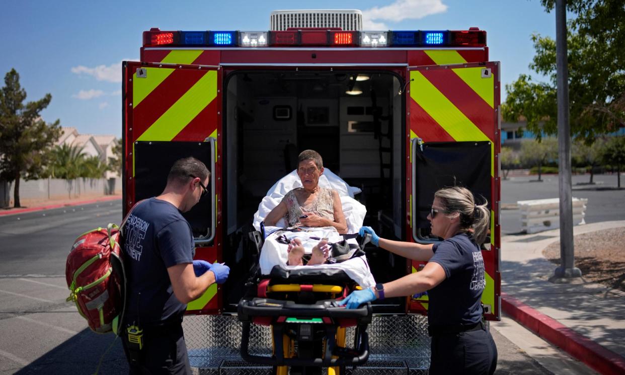 <span>Firefighters help a woman into an ambulance for heat-related symptoms in Henderson, Nevada, on 10 July 2024.</span><span>Photograph: John Locher/AP</span>