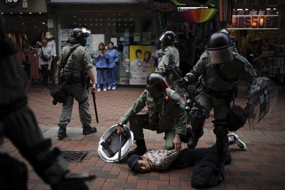 An anti government protester is detained by police at Tseun Wan, Hong Kong, Sunday, Oct.13, 2019. The semi-autonomous Chinese city is in its fifth month of a movement that initially began in response to a now-withdrawn extradition bill that would have allowed Hong Kong residents to be tried for crimes in mainland China. The protests have since ballooned to encompass broader demands for electoral reforms and an inquiry into alleged police abuse. (AP Photo/ Felipe Dana)