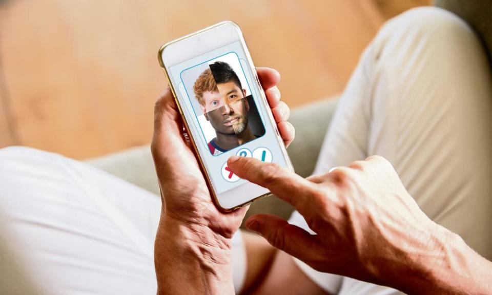 close up of a woman's hand swiping over a composite face on the screen of a phone