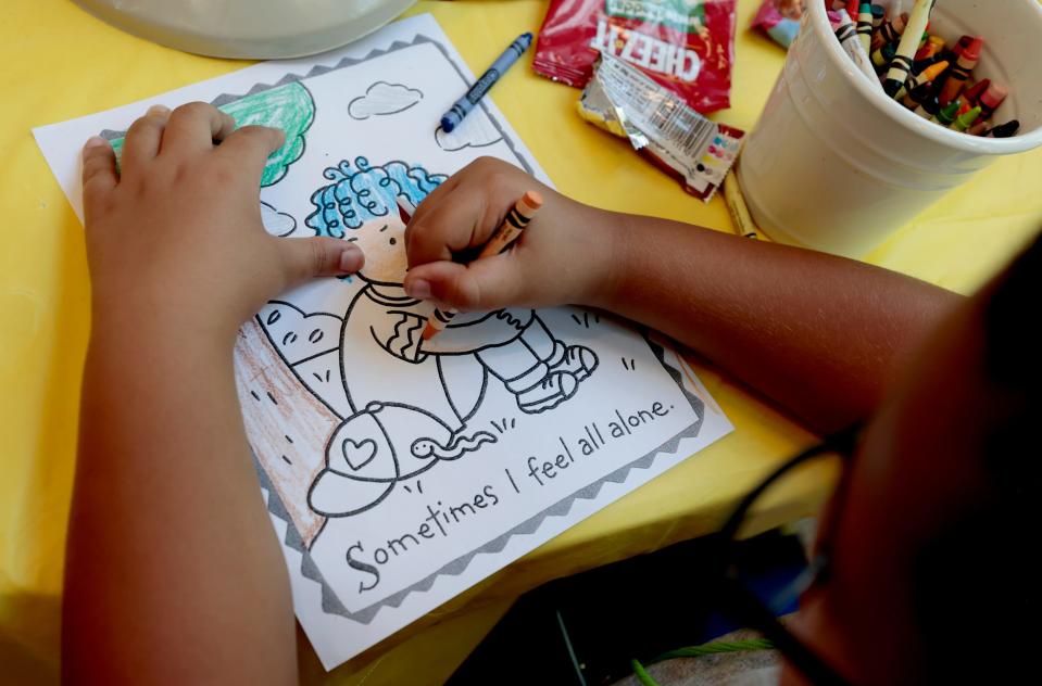 Elijah Brisco, 9, works at coloring on a page with a message during the second annual Camp Monarch run by Angela Hospice Center to play with at the Madonna University Welcome Center in Livonia on August 4, 2023. 
The two-day camp is for children ages 5 to 17 who have experienced the loss of a loved one to allow them to bond with other kids their age, talk about grief and get consoling from adults.