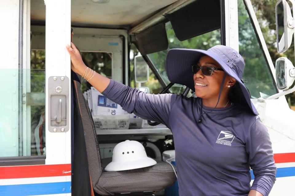 Olivia Gordon, cartera del Servicio Postal de Estados Unidos, aparece en una foto junto a su camión de correo sin aire acondicionado, con el sombrero flexible y la camisa de manga larga que la protegen del sol, el 5 de julio de 2023.