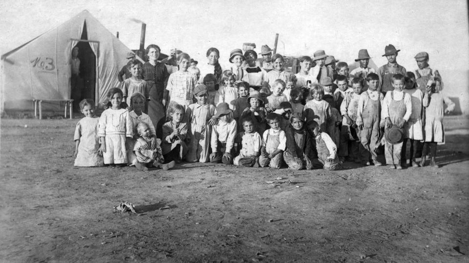 This 1914 photo provided by the Denver Public Library, Western History Collection, shows children and some adults posing for a photo at camp Ludlow in south central Colorado. Two women and 11 children died in a fire at the camp during a battle between the Colorado National Guard and striking coal miners. Sunday April 20, 2014 is the 100th anniversary of the Ludlow Massacre. (AP Photo/Denver Public Library, Western History Collection)