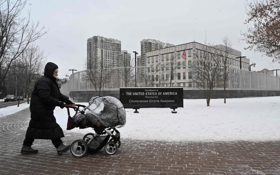 A woman pushes a pram past the US Embassy in Kyiv  - Sergei Supinsky / AFP