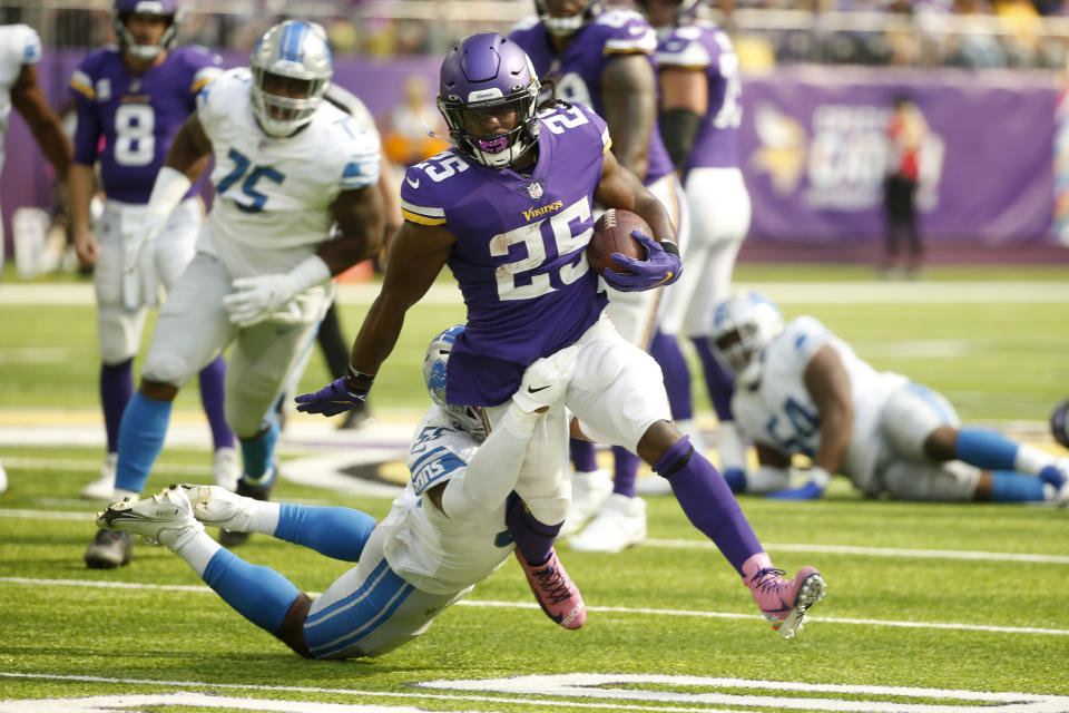 Minnesota Vikings running back Alexander Mattison (25) tries to break a tackle by Detroit Lions inside linebacker Derrick Barnes (55) during the first half of an NFL football game, Sunday, Oct. 10, 2021, in Minneapolis. (AP Photo/Bruce Kluckhohn)