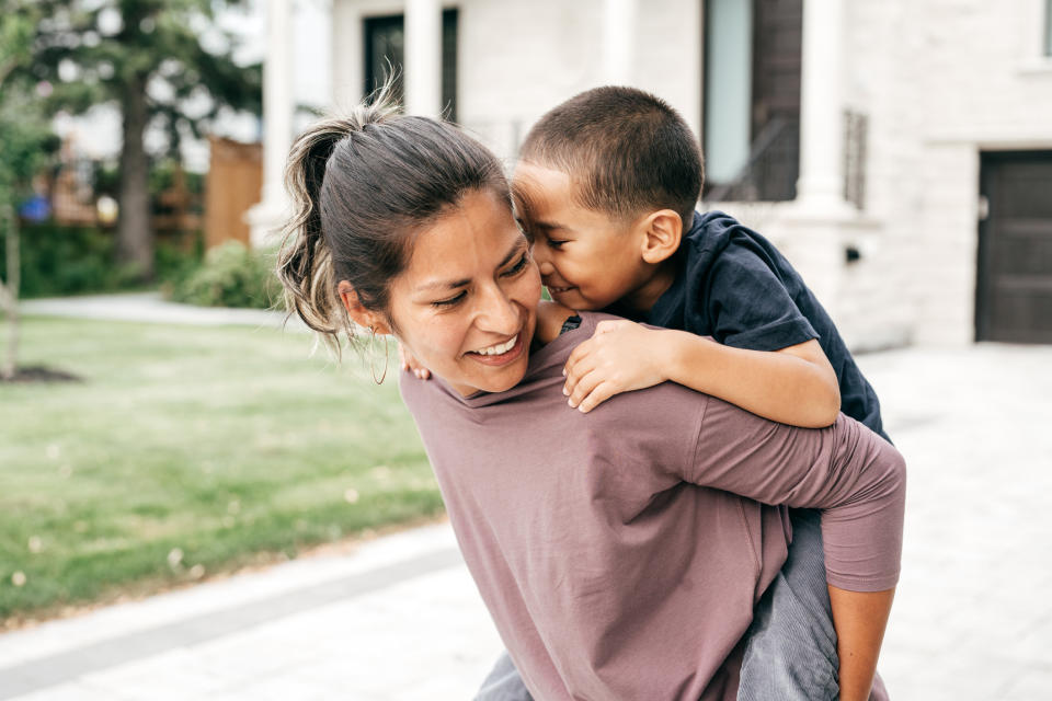 A parent plays with a child outside