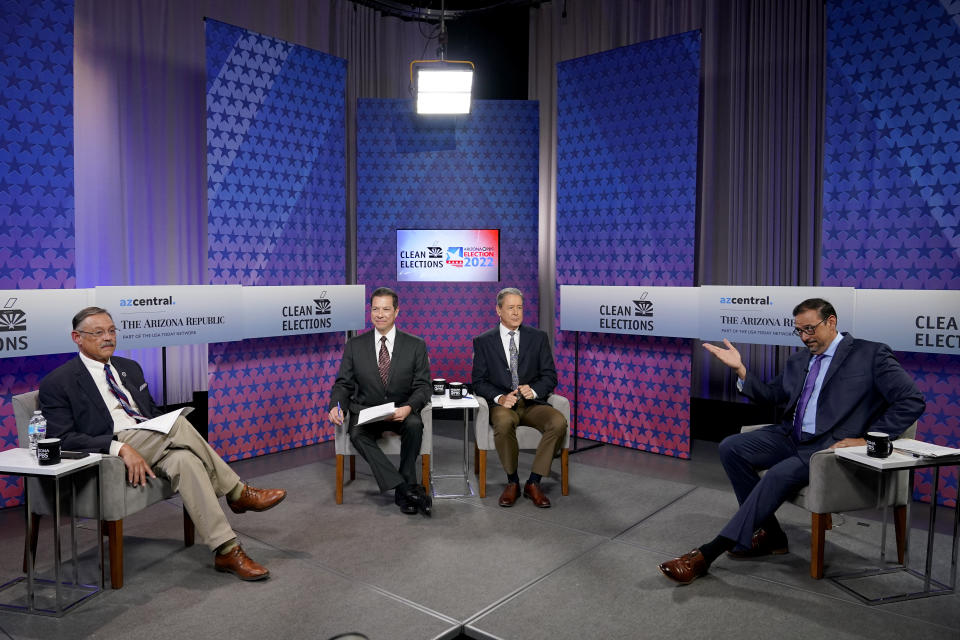 FILE - Arizona Secretary of State Democratic candidate Adrian Fontes, right, and Republican candidate Mark Finchem, left, go over ground rules prior to their debate, Sept. 22, 2022, in Phoenix. Campaign spending in races to oversee state election is setting new records. (AP Photo/Matt York, File)