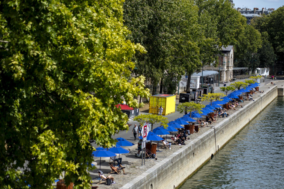 FILE - In this July 28, 2020, file photo, people enjoy the sun on deckchairs along the river Seine in Paris. An outbreak among 18- to 25-year-olds at a seaside resort on the Brittany coast is crystallizing fears that the virus is flaring again in France, on the back of vacationers throwing COVID-19 caution to the summer winds. (AP Photo/Kamil Zihnioglu, File)