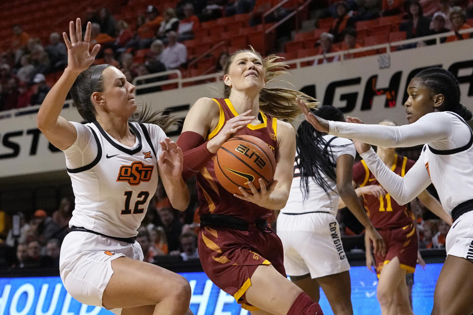 Iowa State guard Ashley Joens, center, drives between Oklahoma State guard Claire Chastain (12) and guard Naomie Alnatas, right, in the first half of an NCAA college basketball game, Wednesday, Feb. 22, 2023, in Stillwater, Okla. (AP Photo/Sue Ogrocki)