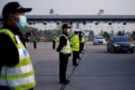 Police officers stand guard at a toll station of an expressway in Wuhan