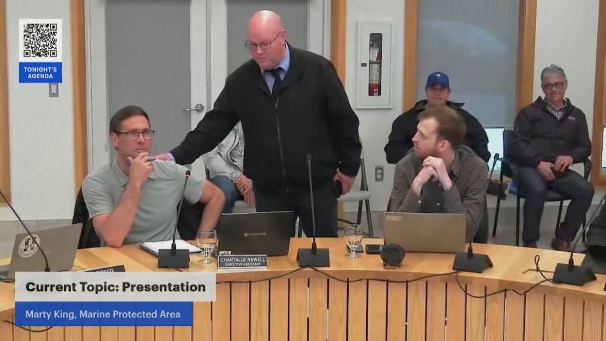 Dan Fleck of the Brazil Rock Lobster Association approaches Marty King with DFO's marine planning group during his appearance Thursday before Argyle municipal council.  (Municipality of the District of Argyle - image credit)