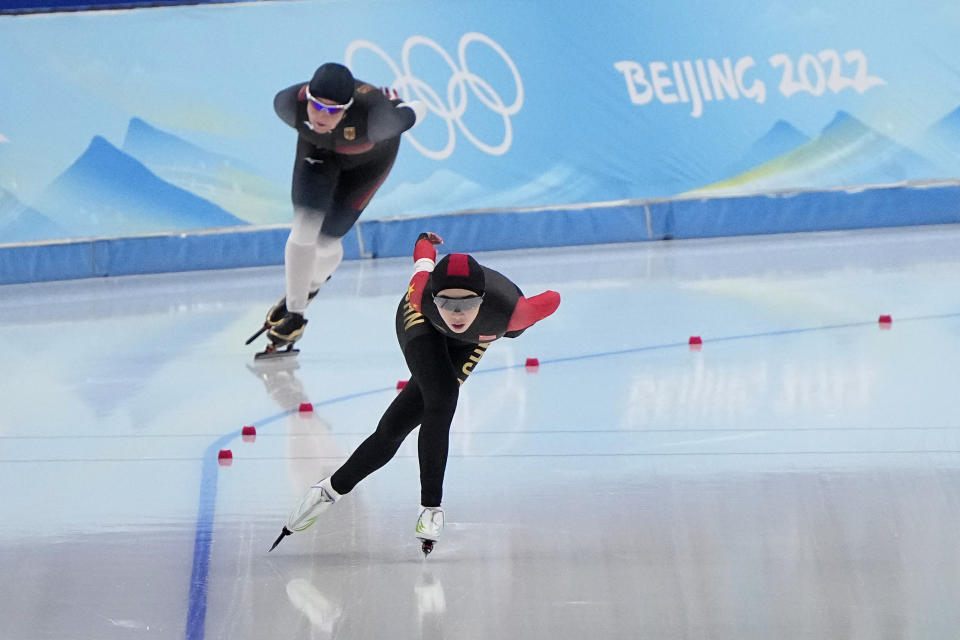 Ahenaer Adake of China, foreground, and Claudia Pechstein of Germany, compete in the women's speedskating 3,000-meter race at the 2022 Winter Olympics, Saturday, Feb. 5, 2022, in Beijing. (AP Photo/Sue Ogrocki)