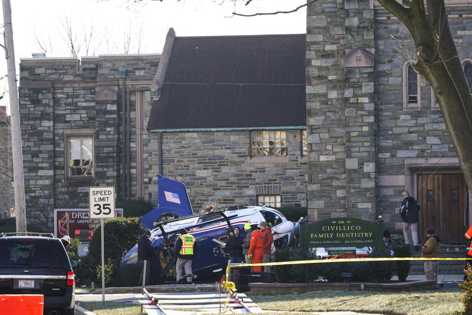 A medical helicopter rests next to the Drexel Hill United Methodist Church after it crashed in the Drexel Hill section of Upper Darby, Pa., on Wednesday, Jan. 12, 2022. Authorities and a witness say a pilot crash landed a medical helicopter without casualties in a residential area of suburban Philadelphia, miraculously avoiding a web of power lines and buildings as the aircraft fluttered, hit the street and slid into bushes outside a church.(AP Photo/Matt Rourke)