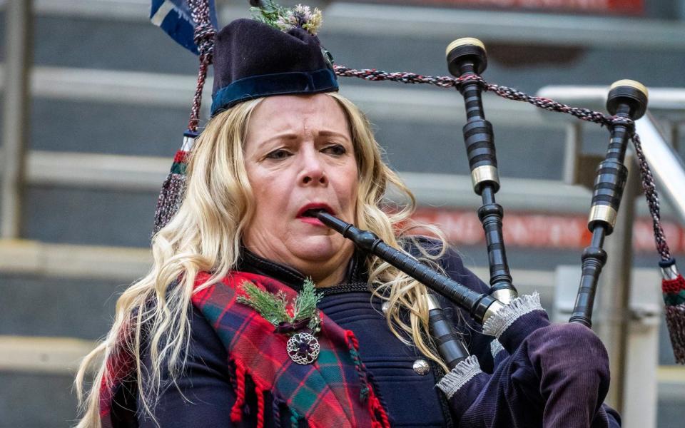 Piper Louise Marshall awaits the arrival of the Duke and Duchess of Cambridge at Edinburgh Waverley Station  - Andy Barr/PA