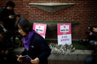 Flowers are placed in front of placards during a protest as a part of the #MeToo movement on International Women's Day in Seoul, South Korea, March 8, 2018. REUTERS/Kim Hong-Ji