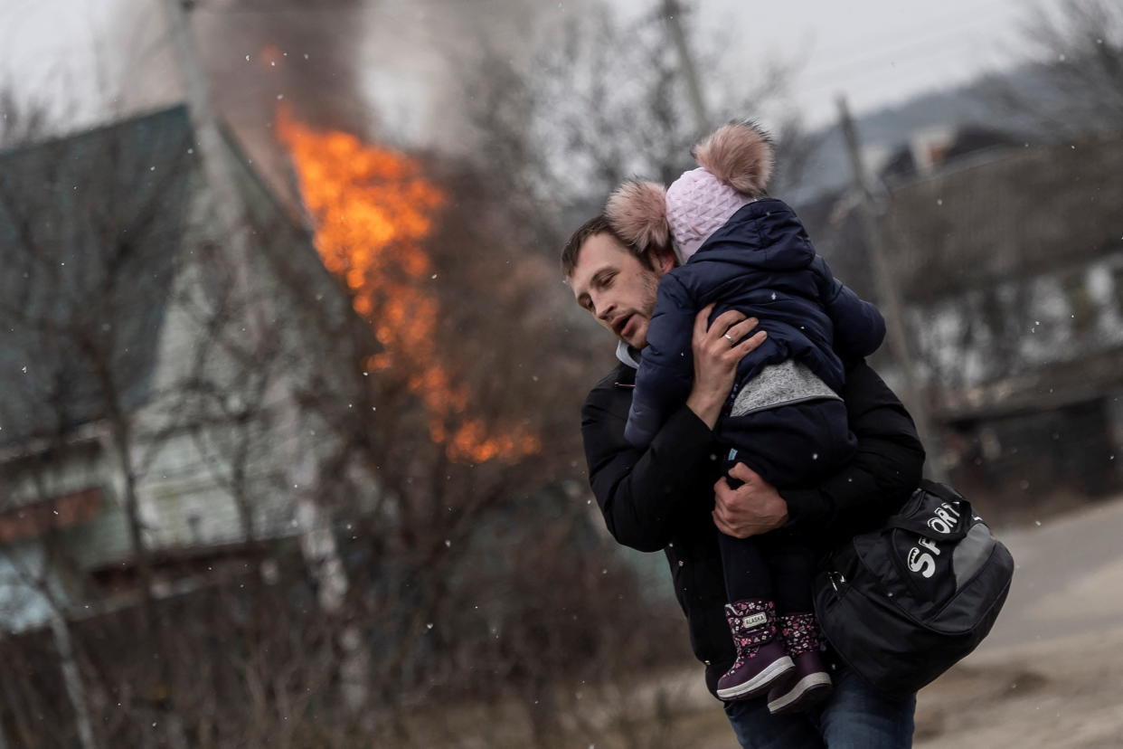 A man and a child escape from the town of Irpin, after heavy shelling on the only escape route used by locals, while Russian troops advance towards the capital of Kyiv, in Irpin, near Kyiv, Ukraine March 6, 2022. (Reuters)