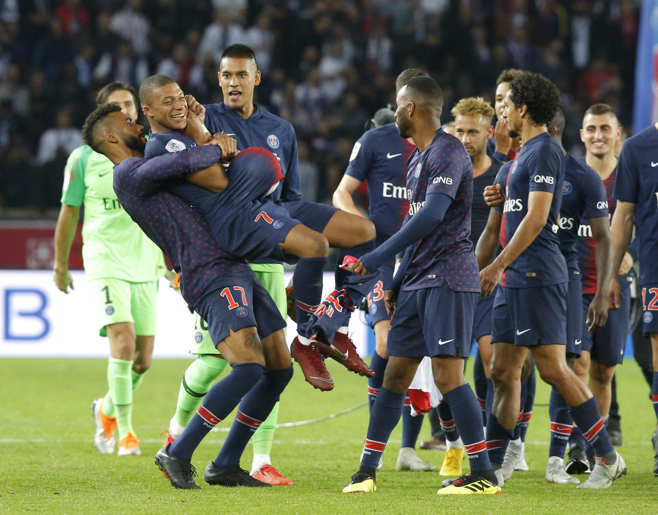 PSG's Eric Maxim Choupo-Moting congratulates PSG's Kylian Mbappe after the French League One soccer match between Paris-Saint-Germain and Lyon at the Parc des Princes stadium in Paris, France, Sunday, Oct. 7, 2018. (AP Photo/Michel Euler)