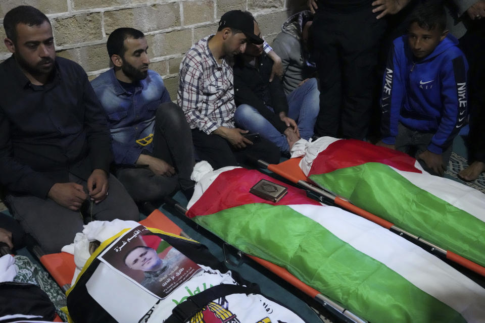 Mourners gather around bodies of Palestinians who were killed in Israeli airstrikes, during their funeral at the Omari mosque in Gaza City, Tuesday, May 9, 2023. The airstrikes killed three senior commanders of the militant Islamic Jihad group and 10 other people, including two of the commanders' wives, several of their children and others nearby. (AP Photo/Adel Hana)