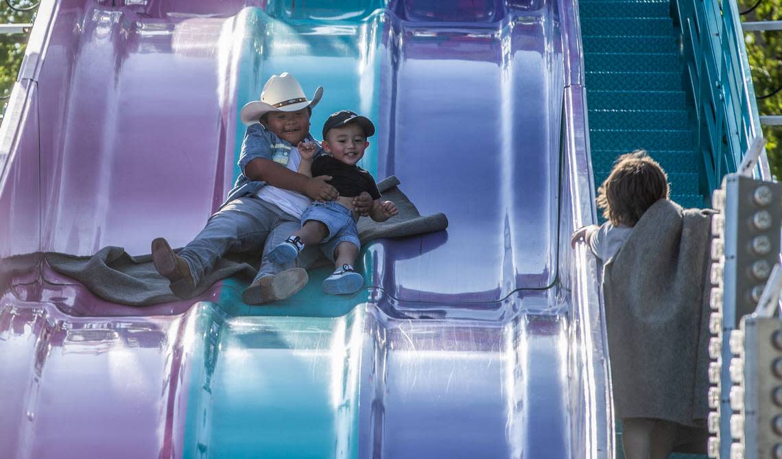 Lino Molina goes for a quick ride down a slide with his nephew Ermias Quinones during a family outing to the Benton Franklin Fair & Rodeo.
