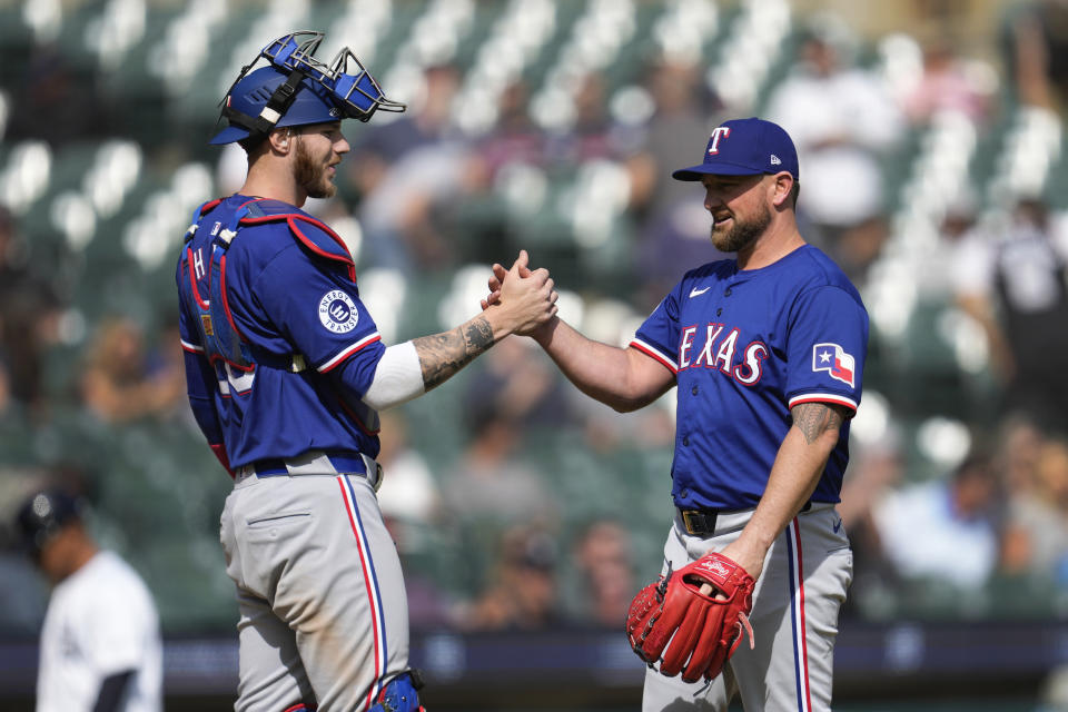 Texas Rangers catcher Jonah Heim, left, and pitcher Kirby Yates (39) celebrate after a baseball game against the Detroit Tigers, Thursday, April 18, 2024, in Detroit. (AP Photo/Paul Sancya)