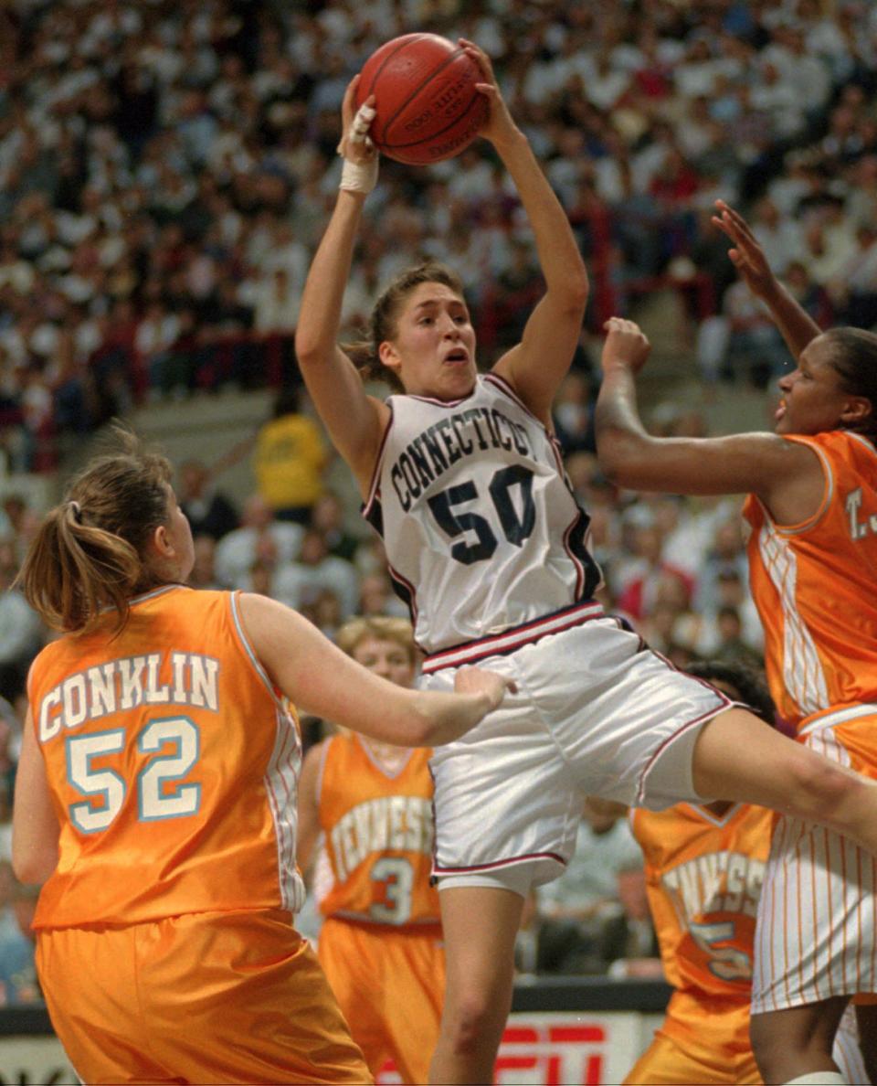 Connecticut's Rebecca Lobo (50) pulls in a rebound as Tennessee's Abby Conklin (52) and Tiffani Johnson, right, come in on the play in the first half at Storrs, Conn., on Jan. 16, 1995.