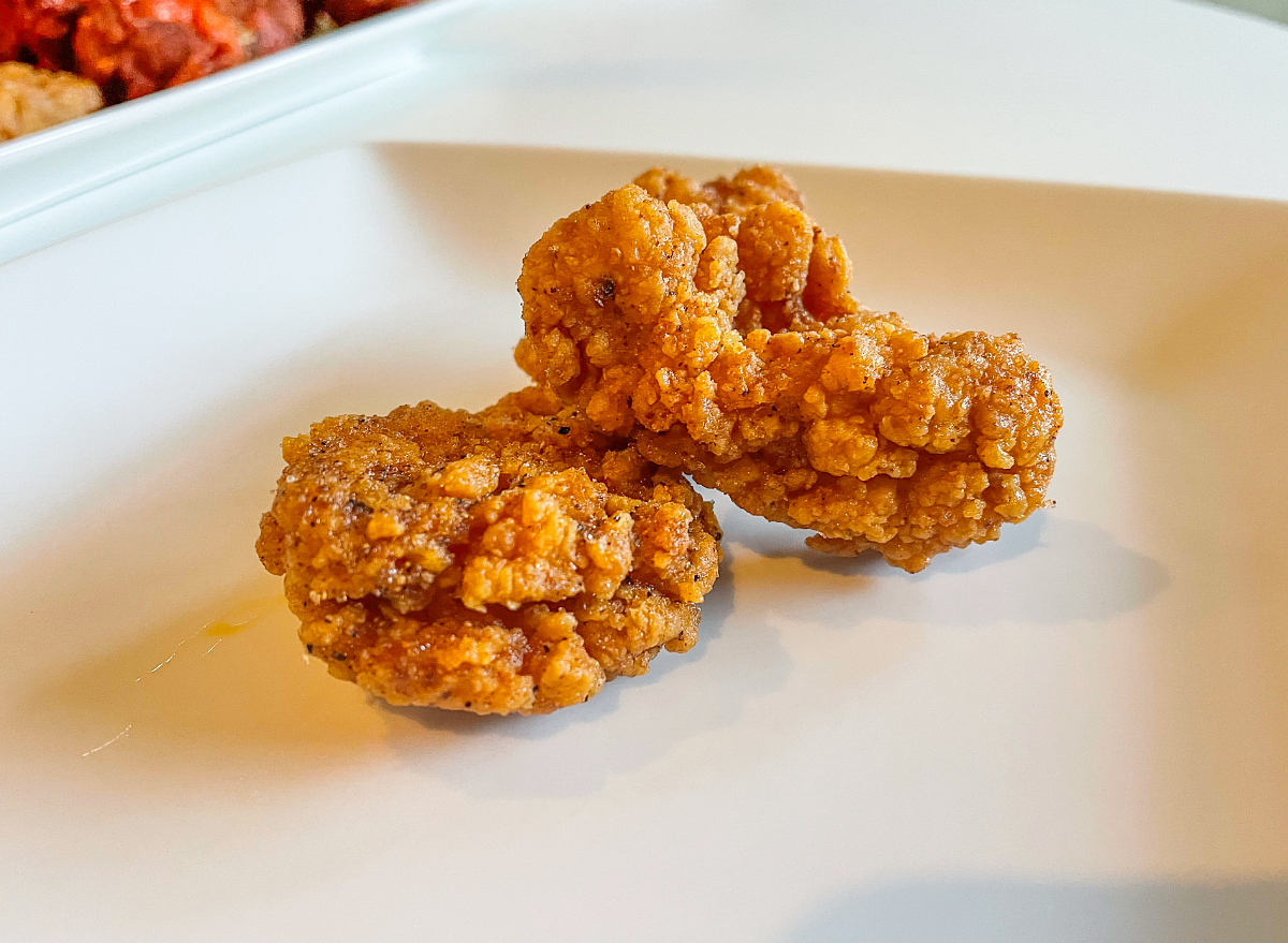 two hot honey wings on a plate.