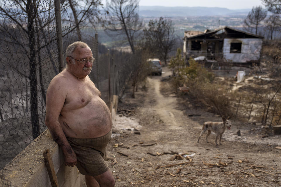 Jordi Villalta, 62, stands next to his house burnt during a wildfire in River Park village, near the town of El Pont de Vilomara, Spain, Tuesday, July 19, 2022. Hundreds of residents evacuated by a wildfire in Bages, in northeastern Spain were anxious to get back to their homes and assess the extent of the damage. Jordi could not even salvage his clothes before escaping the flames, "all I have is what I'm wearing, I've lost everything" Jordi said. (AP Photo/Emilio Morenatti)