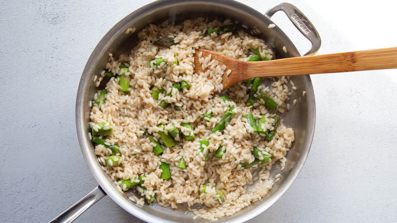 stirring asparagus in risotto