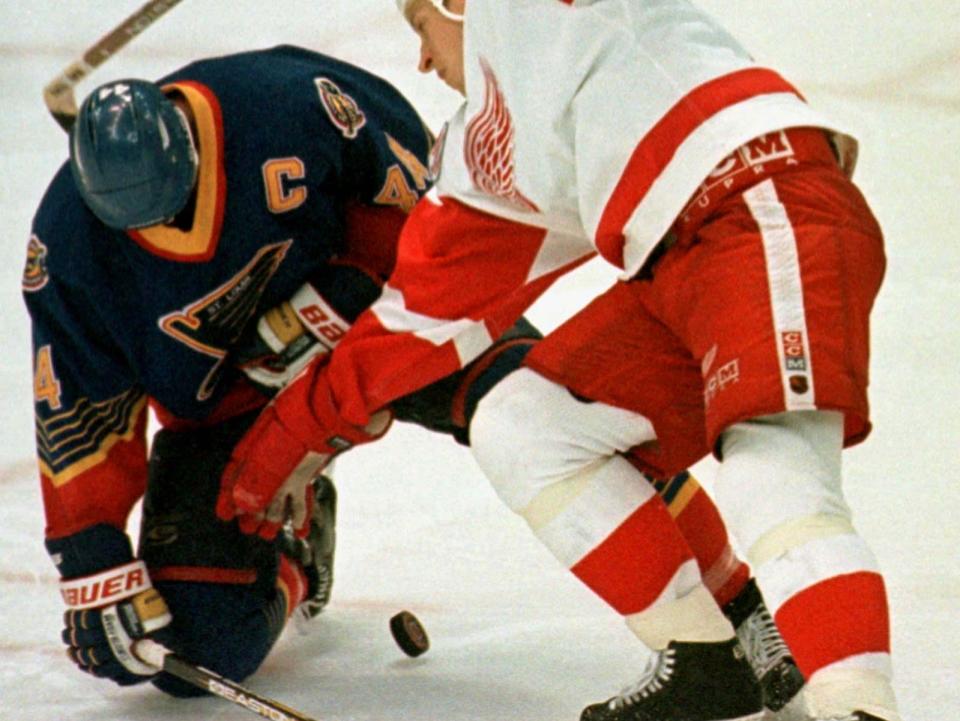 St. Louis Blues' Chris Pronger (L) grabs his chest after being hit with the puck as Detroit Red Wings Dmitri Mironov skates in during play in the third period of game two of the Western Conference semifinal game May 10. Pronger collapsed and was taken by stretcher to the hospital.